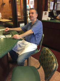 John Koutroubas at the counter.